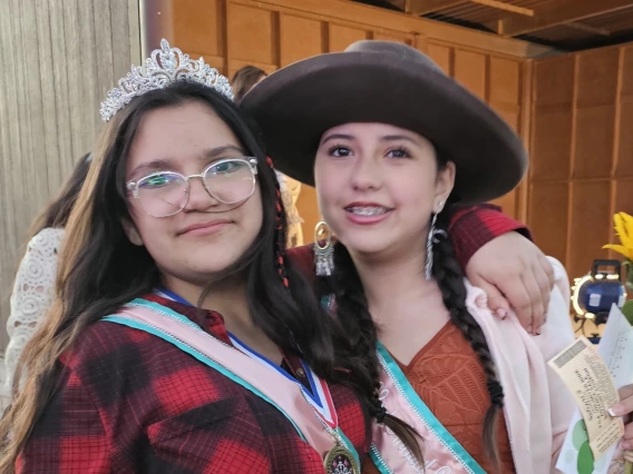 a photo of two people, one with a tiara and one with a wide brim hat